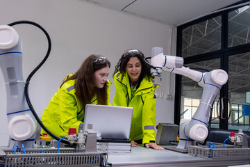 Engineers collaborate on robotic systems in a modern industrial lab during daytime