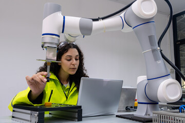 Engineer collaborates with industrial robot in high-tech workspace during daytime