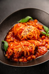 Stuffed cabbage tomato sauce with beans meat, cabbage, fresh delicious gourmet food background on the table rustic food top view copy space