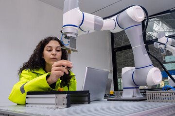 Engineer collaborates with robotic arm in advanced technology lab during daylight
