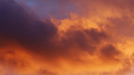 Fototapeta premium Dramatic sunrise with gradient orange and purple clouds, creating a panoramic abstract sky view.