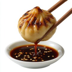 Delicious pan fried dumpling being dipped into soy sauce with chopsticks