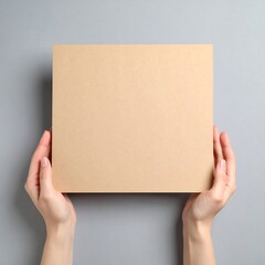 Blank beige cardboard held by hands