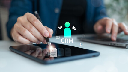 Close-up of a business hand using a digital tablet with CRM interface, symbolizing customer relationship management, client data, marketing automation, and digital business tools.