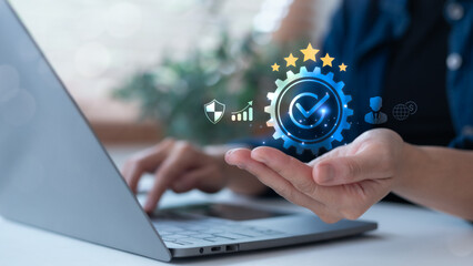 Business hand holding digital gear with checkmark and stars, symbolizing quality assurance, ISO certification, cybersecurity, business performance, and compliance success.