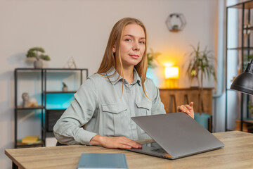 Happy Caucasian businesswoman closing laptop after finishing work. Woman girl freelancer working online, remote job at home office table workplace. E-learning, browsing internet on notebook computer.
