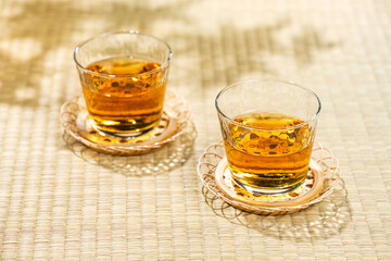 畳の上に置かれた涼しげな麦茶のグラスと茶托