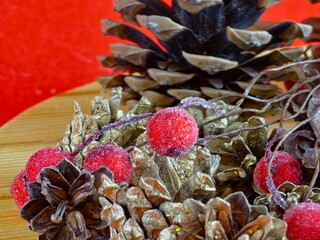 New Year's set for creativity. Natural painted cones and red rowan berries in glaze on a wooden...