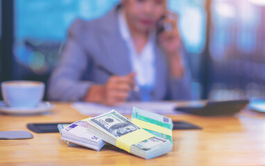 Cash money on the table with accountant woman working as blur background. Selected focus at money.