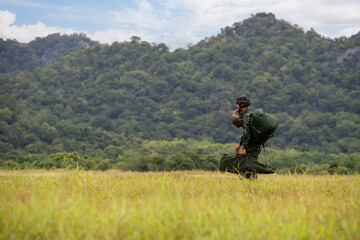 Paratrooper Landing, A soldier safely landing on a grassy field with a parachute after a training...