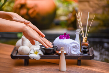 Spa Hand Soak, Relaxing foot spa treatment with herbal compresses, oils, and frangipani flowers in a serene wooden setting.