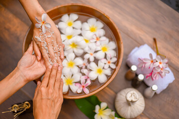 Spa Hand Soak, Relaxing foot spa treatment with herbal compresses, oils, and frangipani flowers in...