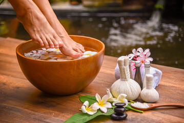 Spa Foot Soak, Relaxing foot spa treatment with herbal compresses, oils, and frangipani flowers in...