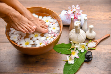 Spa Foot Soak, Relaxing foot spa treatment with herbal compresses, oils, and frangipani flowers in...