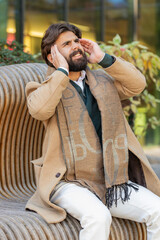 Sick Arabian Indian man feels headache on downtown city street. Young tourist guy massages her...