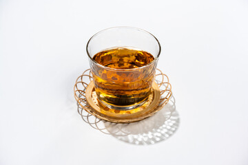 白背景に麦茶を注いだ茶托付きのガラスグラス