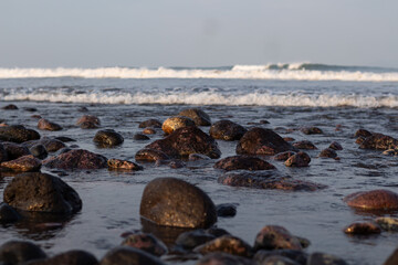 a collection of small and large stones on a beautiful beach on a sunny and cool afternoon