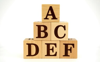 Alphabet blocks stacked in a pyramid formation, spelling out letters A through F, on a white background.