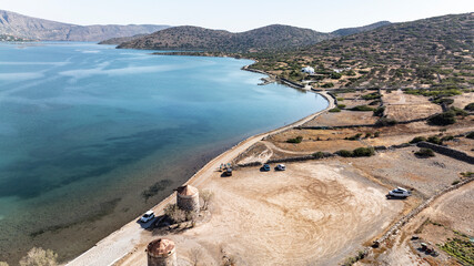 panoramic drone view of ancient mills and canal with bridge near crete island