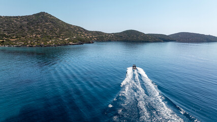panoramic drone view of speedboat on blue water near crete island