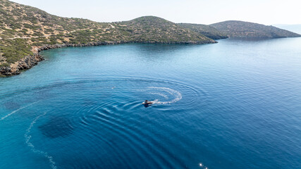 panoramic drone view of speedboat on blue water near crete island