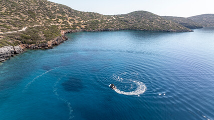 panoramic drone view of speedboat on blue water near crete island