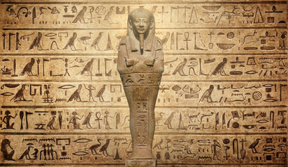 Old Egyptian hieroglyphs and Egyptian figurineon an ancient background. Wide historical background. Ancient Egyptian hieroglyphs as a symbol of the history of the Earth.