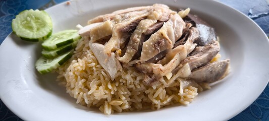 Chicken rice on a white plate in a restaurant