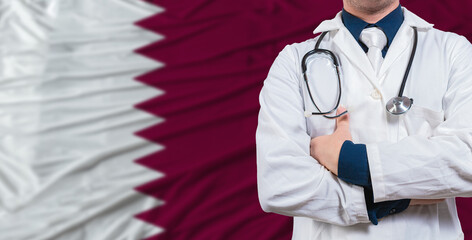Male doctor with stethoscope on Qatar flag. Doctor holding stethoscope on Qatar flag