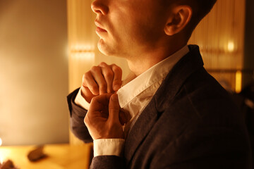 Man in stylish outfit getting ready indoors, closeup
