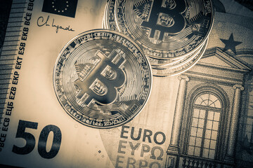 Bitcoin on the background of euro bills. Cryptocurrency concept.