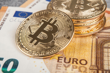 Bitcoin on the background of euro bills. Cryptocurrency concept.