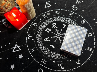 Tarot cards are laid out on the table, candles are burning nearby. Space for text. Top view.