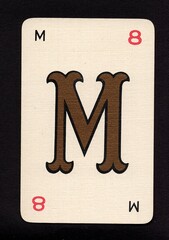 A decorative playing card featuring a letter from the English alphabet isolated on a black background.