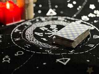 Tarot cards are laid out on the table, candles are burning nearby. Space for text.