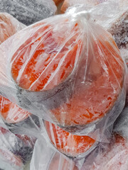 Frozen salmon steaks in a plastic bag on the counter at the fish market