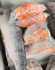 Frozen salmon steaks in a plastic bag on the counter at the fish market
