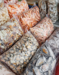 A variety of frozen seafood in plastic bags at the fish market
