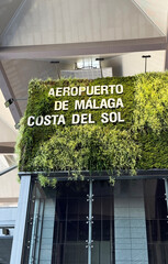 Malaga, Spain - July 02, 2025: Malaga Airport Costa del Sol sign with lush greenery, modern architecture, and vibrant atmosphere for travelers