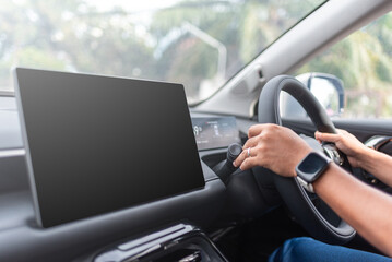 Driver hand on steering wheel with blank car dashboard touchscreen ready for interface design, perfect for UI/UX mockup, navigation app, or modern vehicle technology content.
