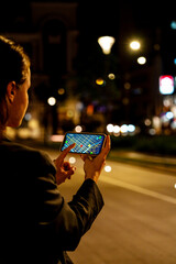 Female pedestrian using mobile navigation app on city street at night