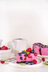 Summer fruit and berry no-baked cheesecake. Creamy whipped cake with chocolate sponge cake, with...