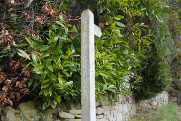Eyam, The Peak District, England - January 21 2025: Weathered Wooden Signpost to Riley Graves...