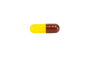 Yellow and brown herbal medicine capsule. For concepts of natural supplements, vitamins, turmeric, or fish oil. isolated on white background with clipping path.