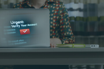 An urgent on-screen notification prompts a woman working on her laptop to verify her account, highlighting the pervasive threat of an online scam