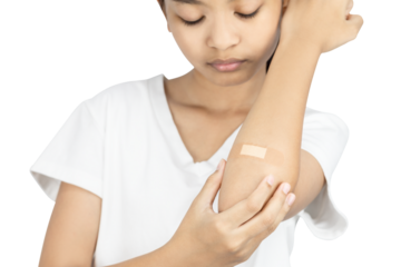 Close-up of a young Asian girl with a bandage on her elbow. First aid for a minor injury or wound care concept isolated on white background with clipping path.