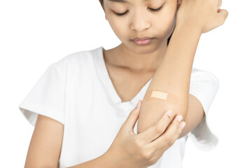 Close-up of a young Asian girl with a bandage on her elbow. First aid for a minor injury or wound care concept isolated on white background with clipping path.