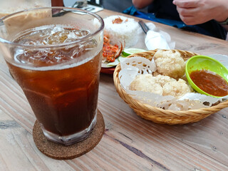 Spicy Indonesian smashed fried chicken (ayam geprek) served with steamed rice, cucumber, lettuce,...
