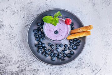 Abstract composition: blueberry smoothie mixed with spirulina, creating swirls of blue and purple tones