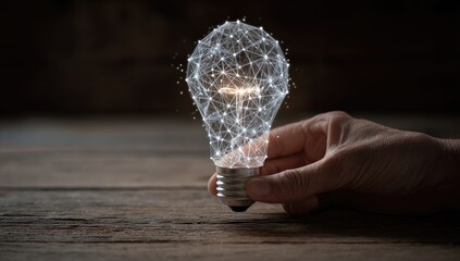 Hand holding a digital lightbulb on a wooden table.  Abstract, tech